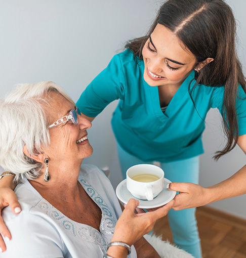 caretaker giving senior tea