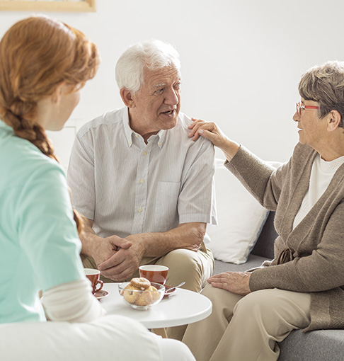 senior woman and man talking with caregiver