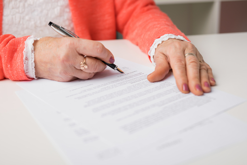 senior woman signing papers