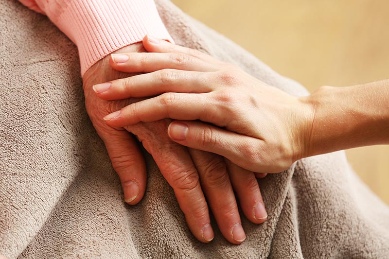 Caregiver Holding Seniors Hand