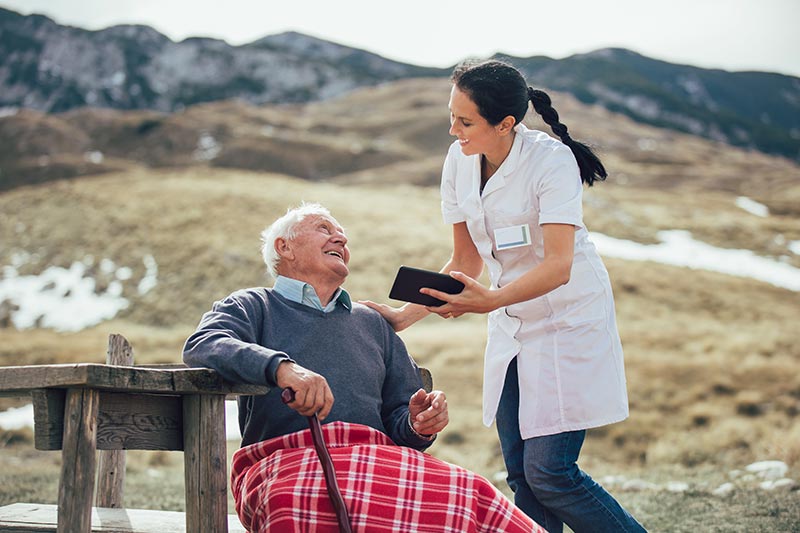 elderly man outside with caregiver