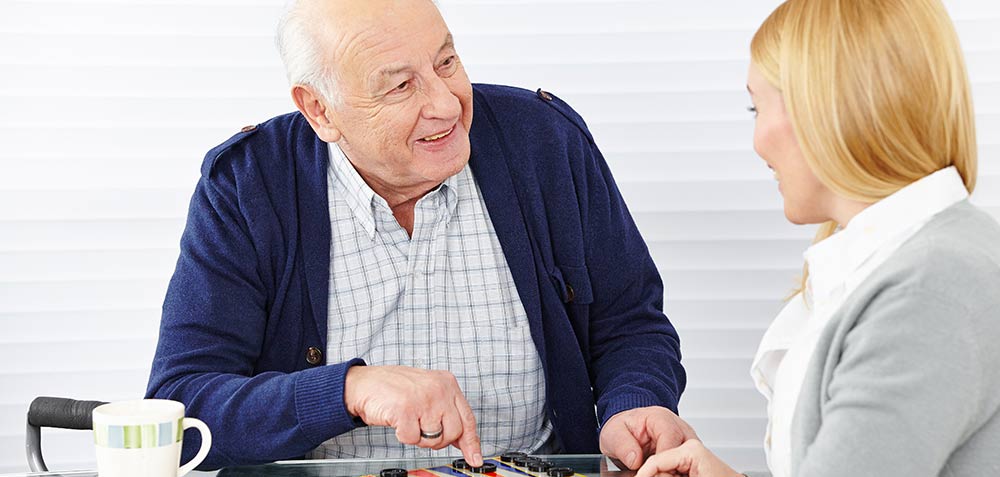 Senior and Caregiver playing Checkers