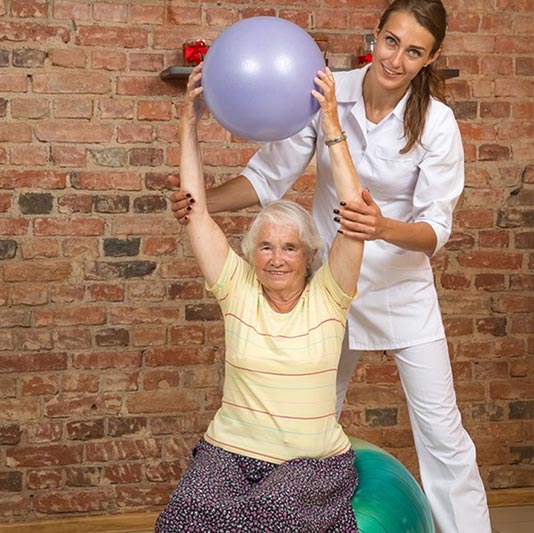 Senior Exercising with Caregiver