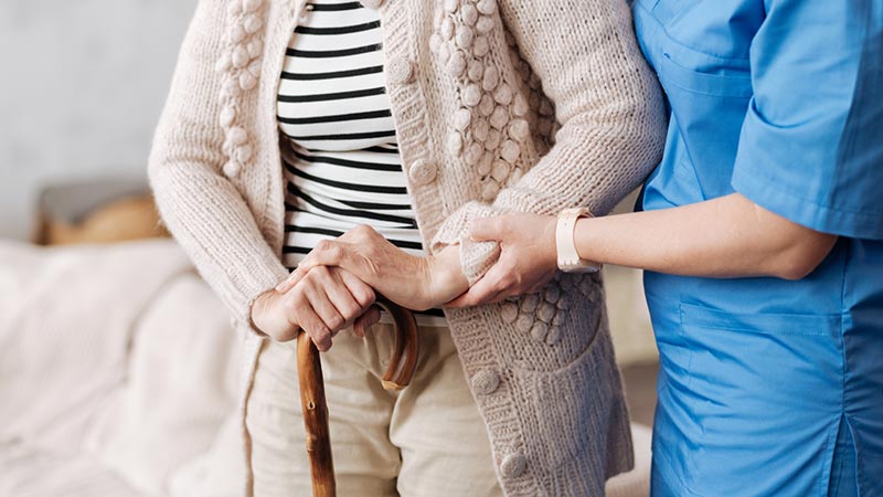 Senior Getting Help from Caregiver