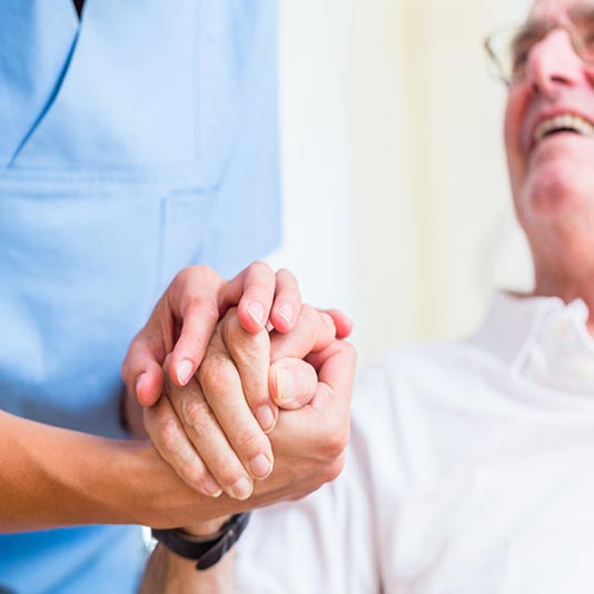 Senior Man Holding Hands With Caregiver