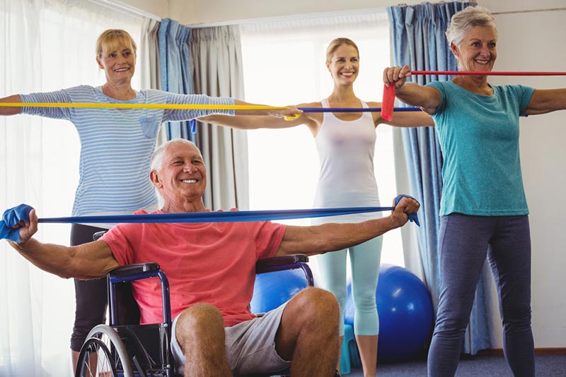 Seniors Stretching with Caregiver