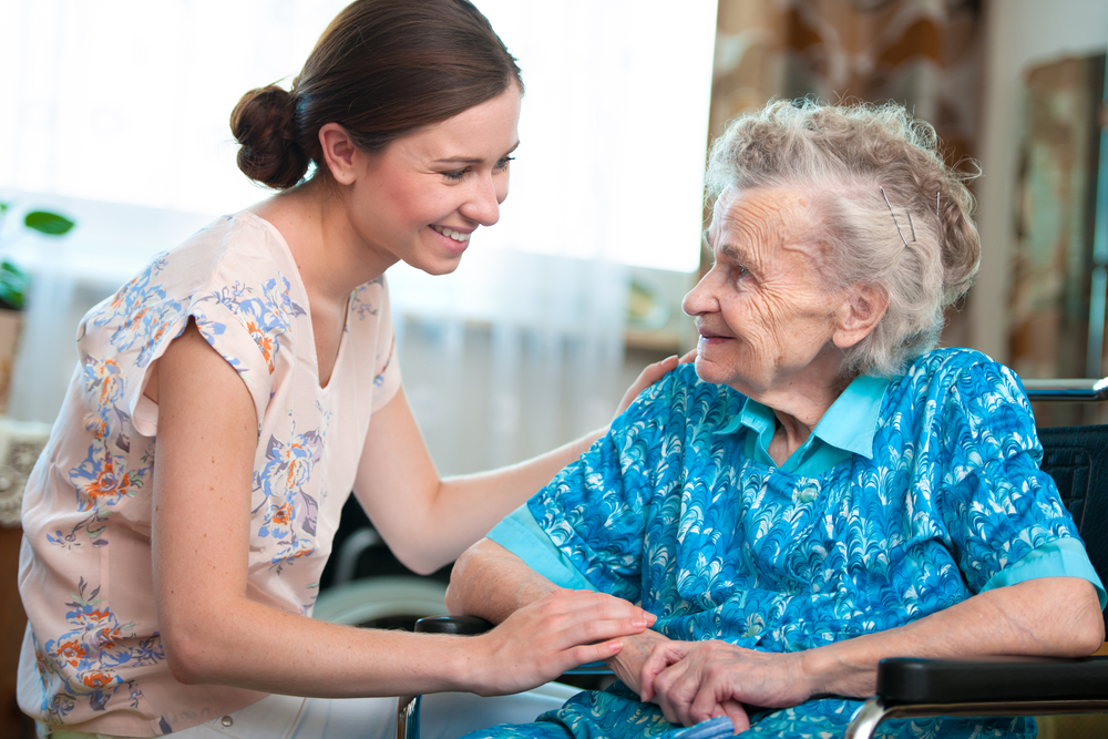 caregiver helping a woman in a wheelchair