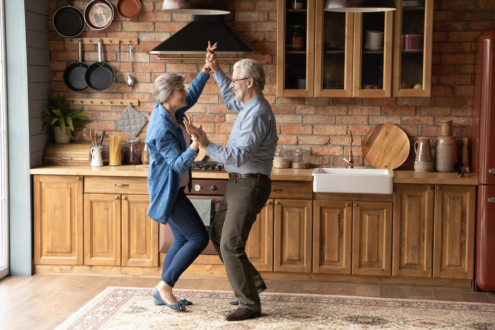 two seniors dancing and enjoying life in their kitchen