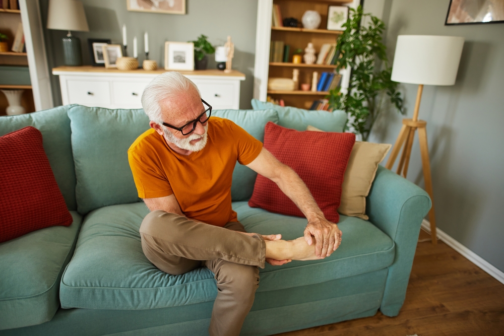 Older man sitting on the couch managing arthritis pain
