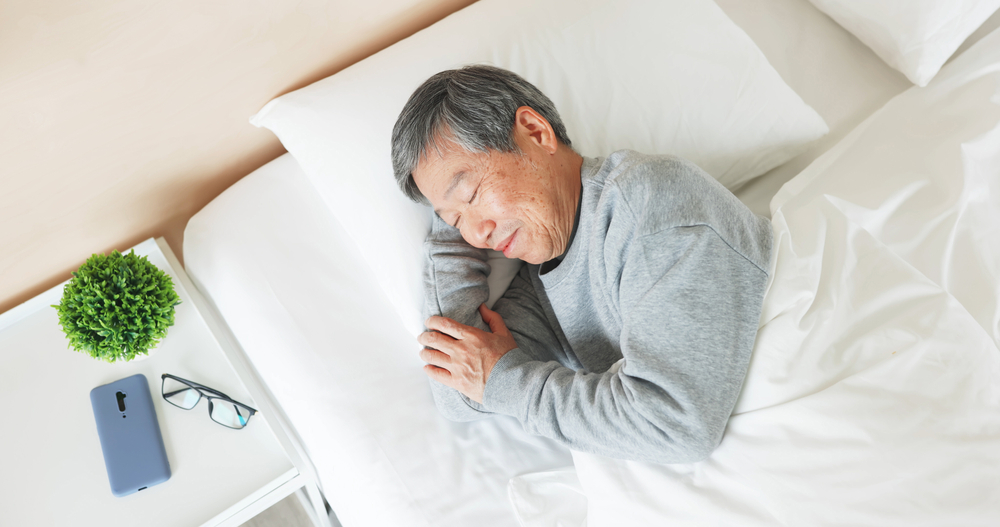 A senior man sleeping peacefully in bed.