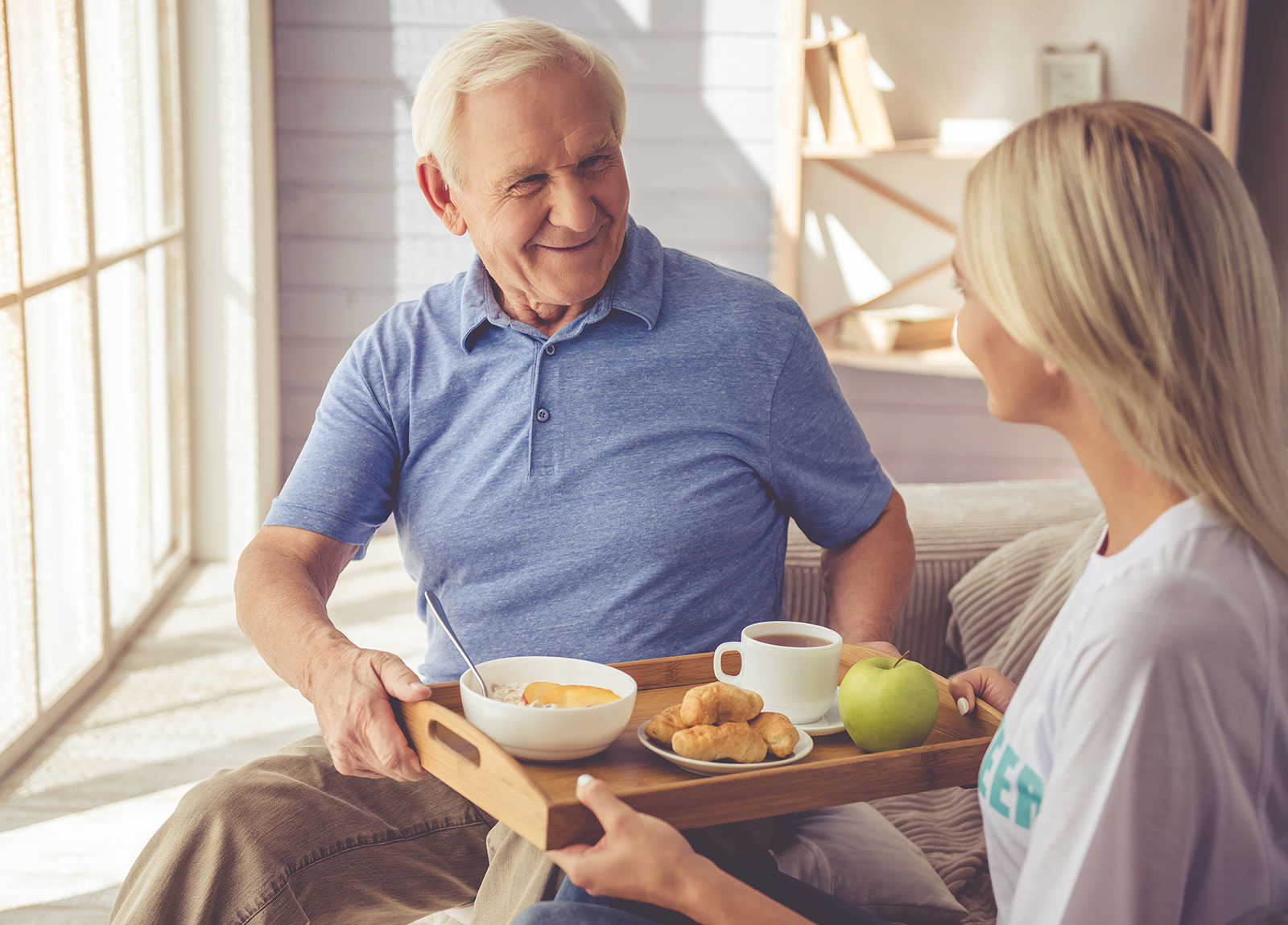 caregiver providing senior man with a nutritious meal