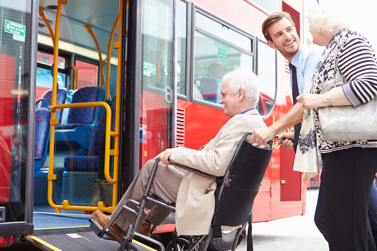 driver helping seniors board a bus