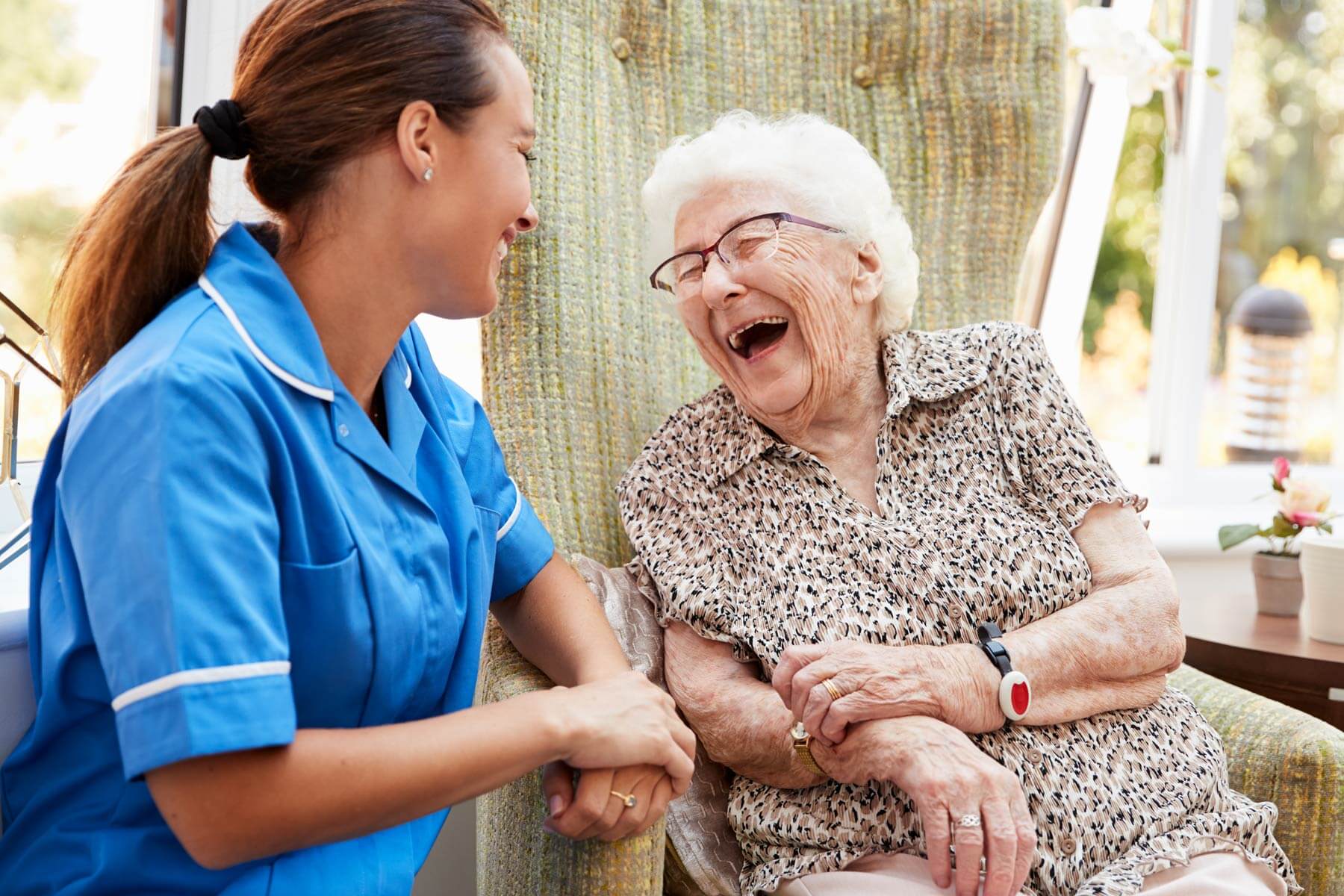 Elderly woman laughing with caregiver