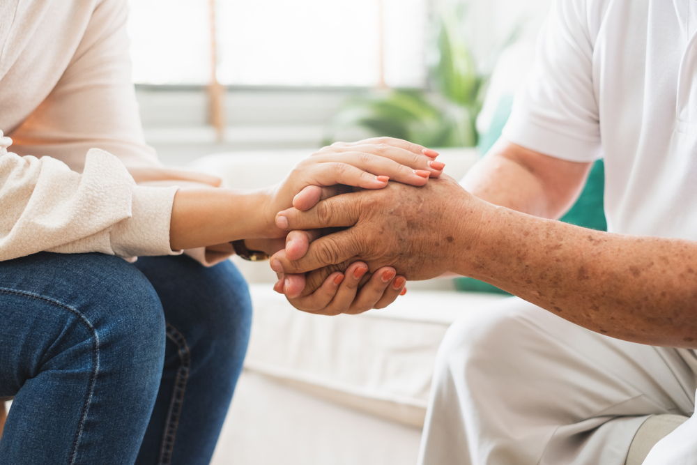 caregiver holding patient's hands