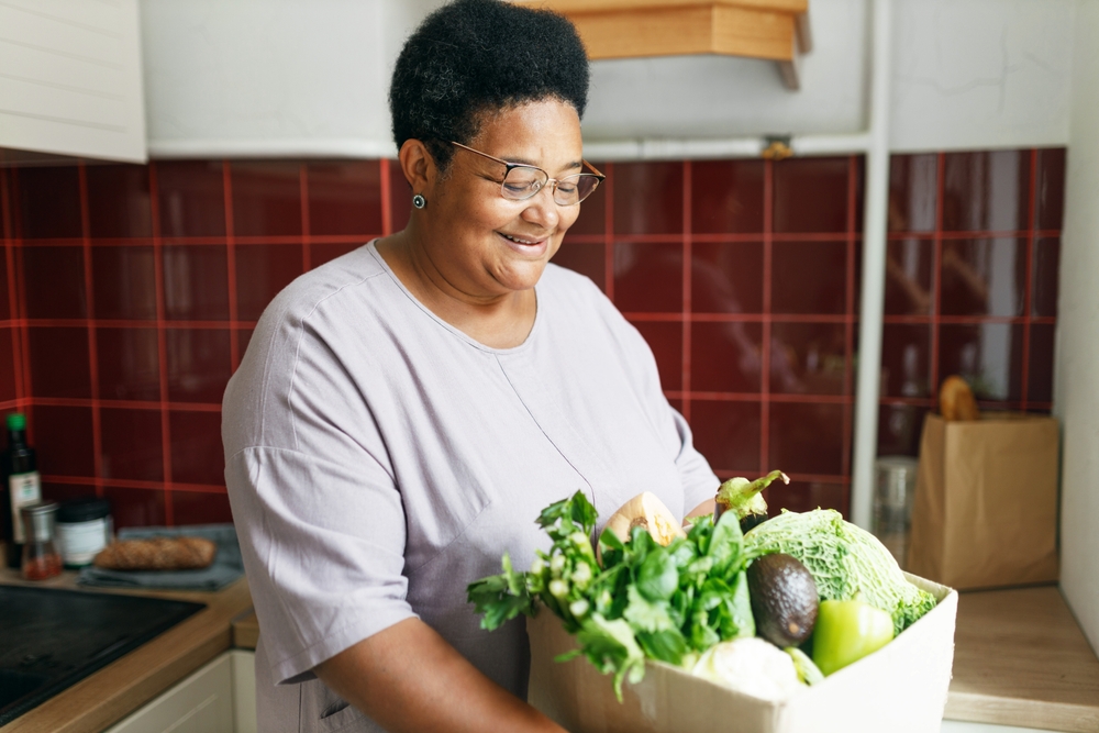 African American Senior Female Holding Big Carton Of Fresh Produce