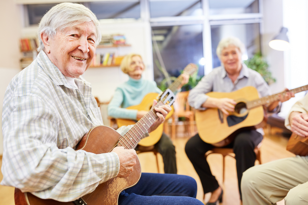 Aînés jouant de la guitare ensemble en musicothérapie.